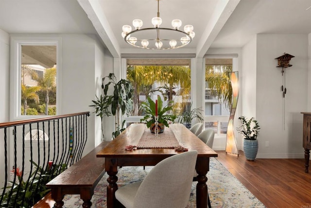 dining room featuring wood-type flooring and an inviting chandelier