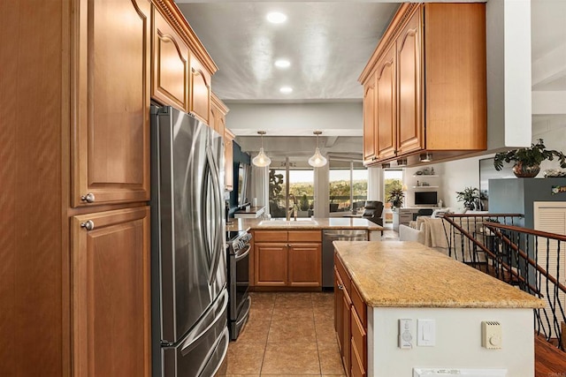 kitchen with brown cabinetry, a center island, stainless steel appliances, dark tile patterned floors, and a sink