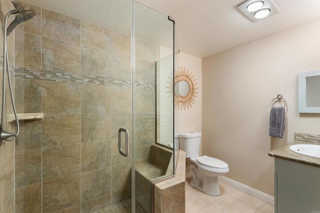 bathroom featuring toilet, vanity, a shower stall, a textured ceiling, and tile patterned flooring