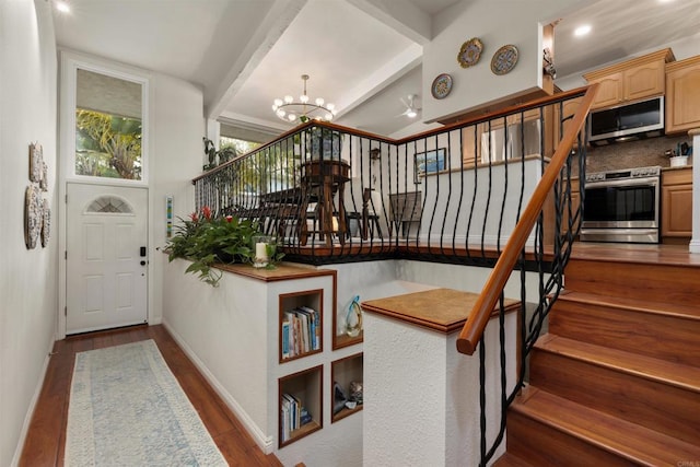 stairway featuring beam ceiling, a notable chandelier, baseboards, and wood finished floors