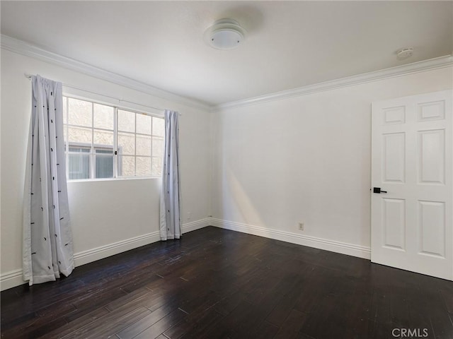 spare room with ornamental molding and dark hardwood / wood-style flooring