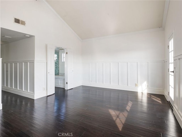 empty room featuring crown molding, high vaulted ceiling, and dark hardwood / wood-style flooring