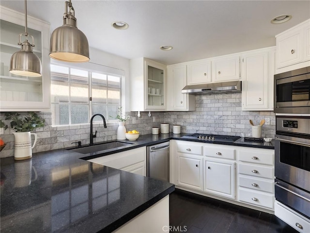 kitchen with pendant lighting, white cabinetry, sink, backsplash, and stainless steel appliances