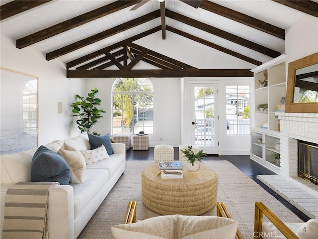 living room with vaulted ceiling with beams, dark hardwood / wood-style floors, and a brick fireplace