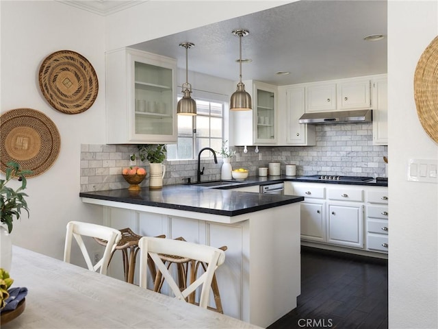 kitchen featuring a breakfast bar, sink, white cabinets, hanging light fixtures, and kitchen peninsula