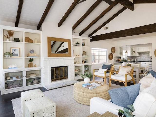 living room with sink, dark wood-type flooring, beam ceiling, high vaulted ceiling, and a brick fireplace