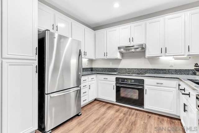 kitchen with white cabinetry, stainless steel appliances, light hardwood / wood-style flooring, and dark stone counters