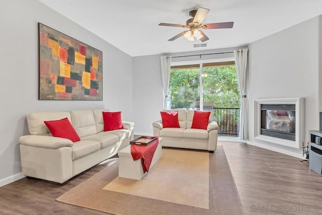 living room featuring wood-type flooring and ceiling fan