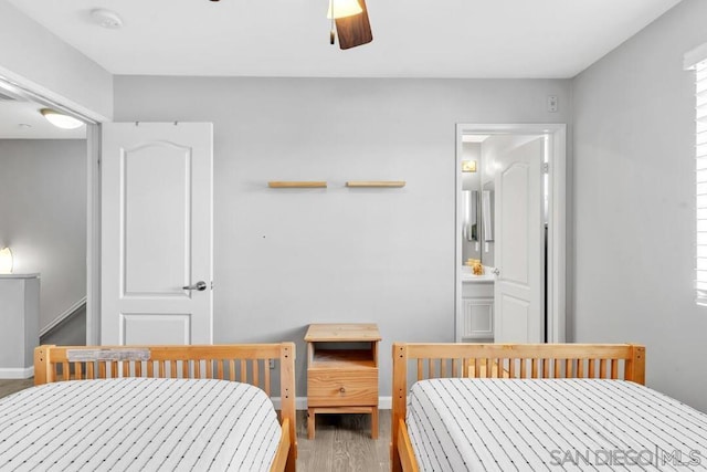 bedroom featuring connected bathroom, hardwood / wood-style floors, and ceiling fan