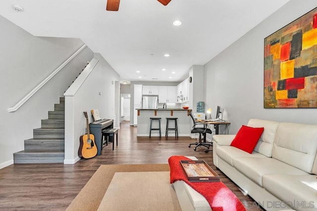 living room featuring ceiling fan and dark hardwood / wood-style floors