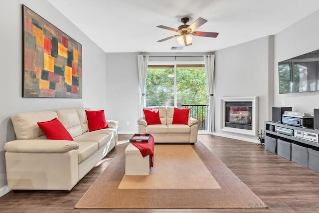 living room with dark hardwood / wood-style floors and ceiling fan