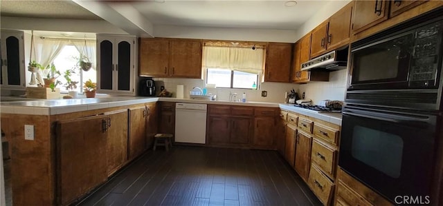 kitchen featuring stainless steel gas cooktop, dark hardwood / wood-style floors, dishwasher, kitchen peninsula, and black double oven