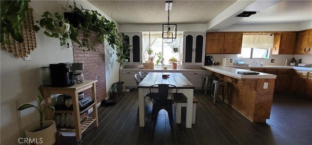 kitchen with dark hardwood / wood-style floors, a center island, pendant lighting, and a kitchen bar