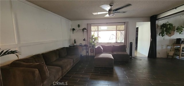 living room featuring ceiling fan and a textured ceiling