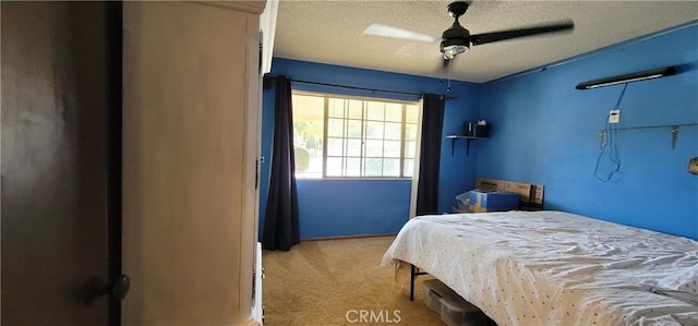 carpeted bedroom featuring ceiling fan and a textured ceiling