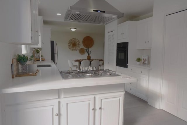 kitchen featuring white cabinetry, stainless steel appliances, and exhaust hood