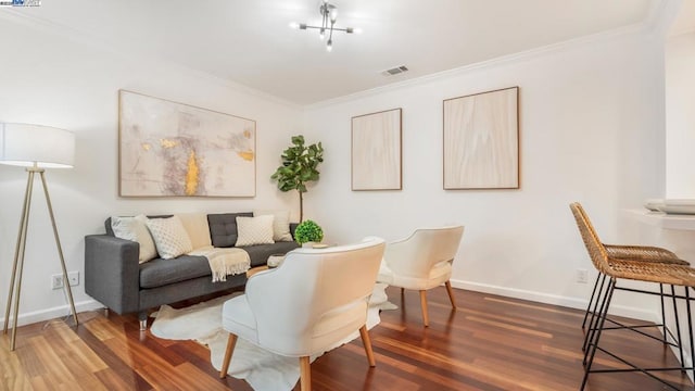 sitting room with dark hardwood / wood-style flooring and crown molding