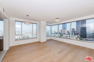 spare room with plenty of natural light and hardwood / wood-style floors