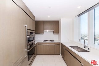 kitchen featuring floor to ceiling windows, plenty of natural light, sink, and black gas cooktop