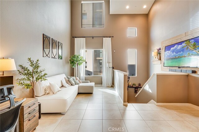 living room featuring light tile patterned floors and a high ceiling