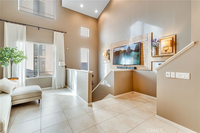 interior space with a towering ceiling and light tile patterned flooring