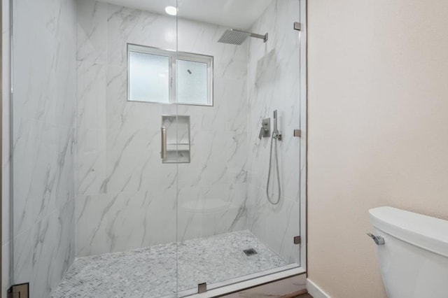 bathroom featuring walk in shower and toilet