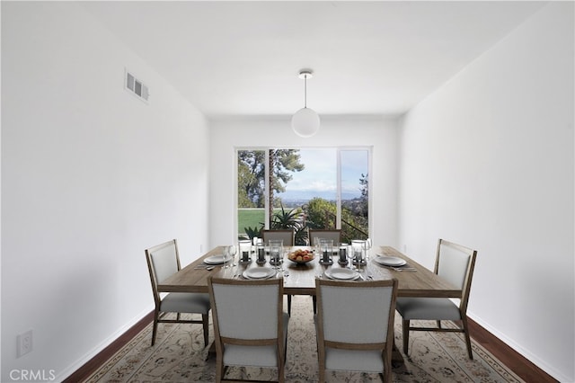 dining room featuring baseboards, visible vents, and wood finished floors