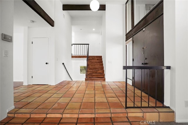 hallway with beamed ceiling and a towering ceiling