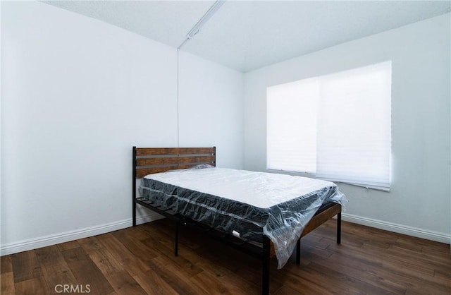 bedroom with dark hardwood / wood-style floors