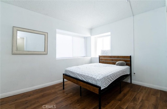 bedroom featuring dark hardwood / wood-style floors and a textured ceiling