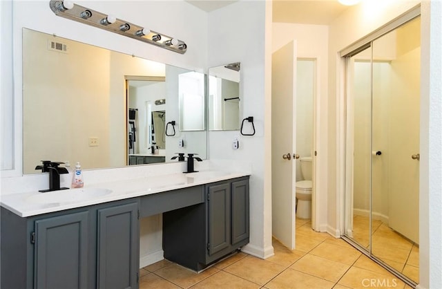 bathroom featuring vanity, tile patterned flooring, and toilet