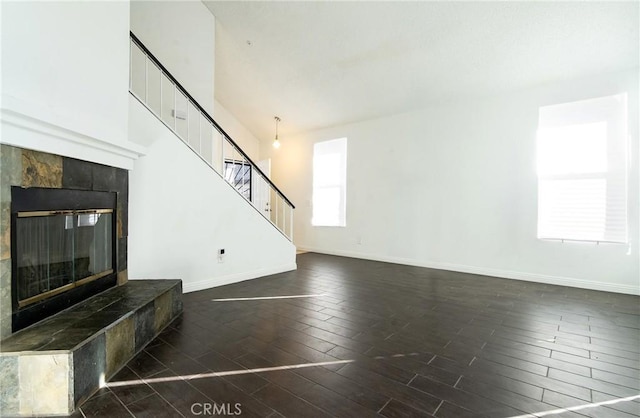 unfurnished living room with a fireplace, dark hardwood / wood-style floors, and a high ceiling