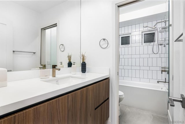 full bathroom with vanity, tiled shower / bath, and toilet