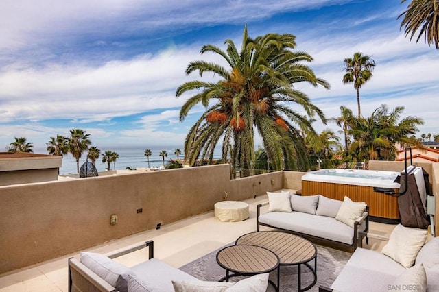 view of patio featuring a water view, a hot tub, and outdoor lounge area