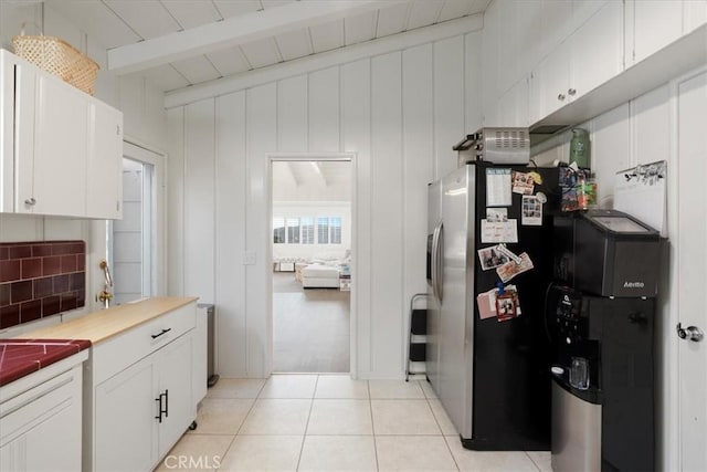 kitchen featuring light tile patterned floors, white cabinetry, beam ceiling, tasteful backsplash, and stainless steel fridge with ice dispenser