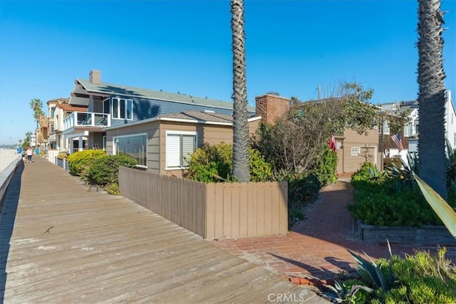 exterior space featuring a chimney and fence