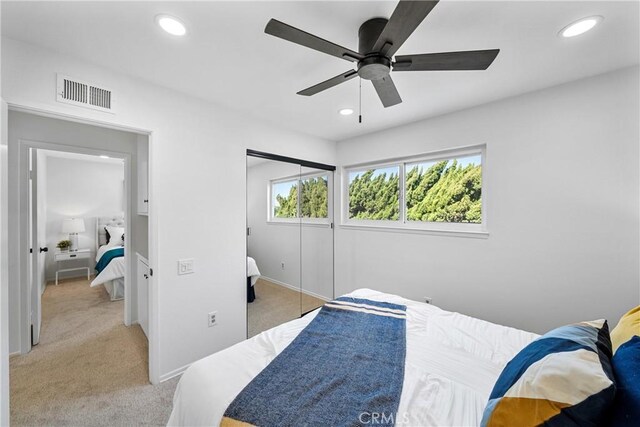 carpeted bedroom featuring a closet and ceiling fan