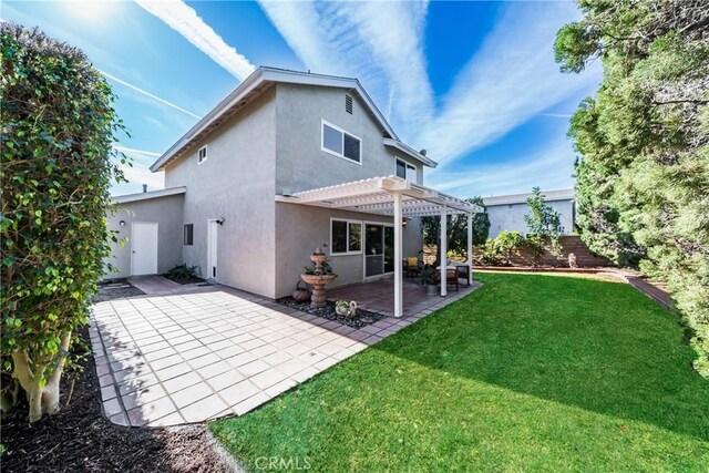 rear view of property featuring a yard, a patio area, and a pergola