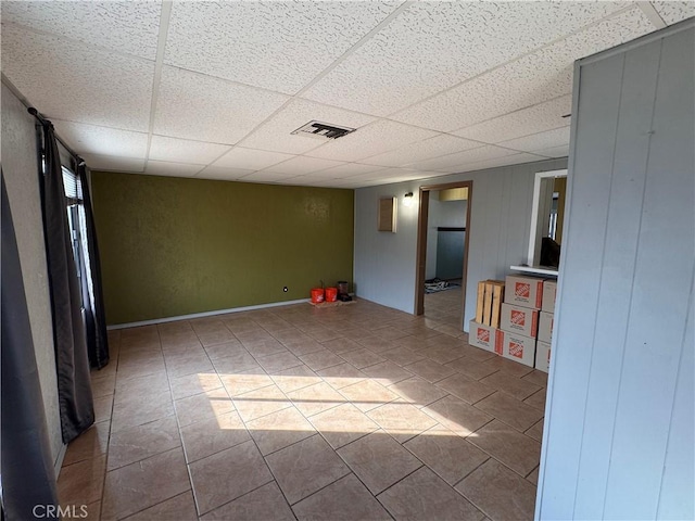 tiled empty room with a paneled ceiling