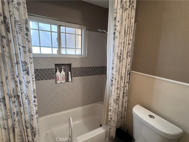 bathroom with shower / bathtub combination with curtain and toilet