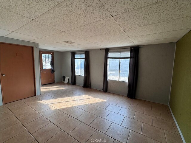 1704 Sunrise Rd, Barstow, CA 92311 - tiled empty room featuring a paneled ceiling