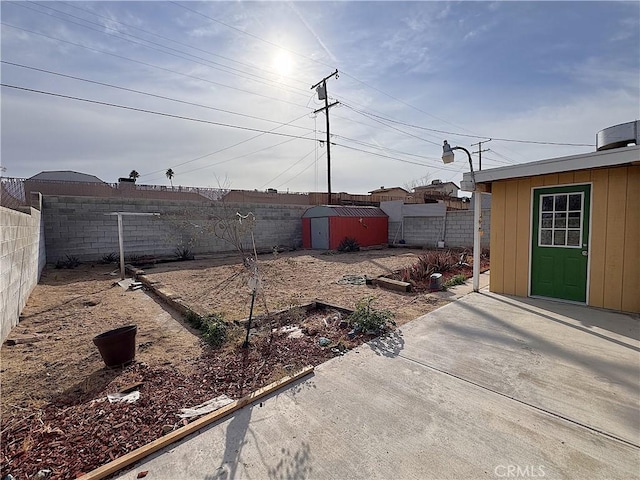 1704 Sunrise Rd, Barstow, CA 92311 - fenced backyard with a patio area, an outdoor structure, and a storage unit