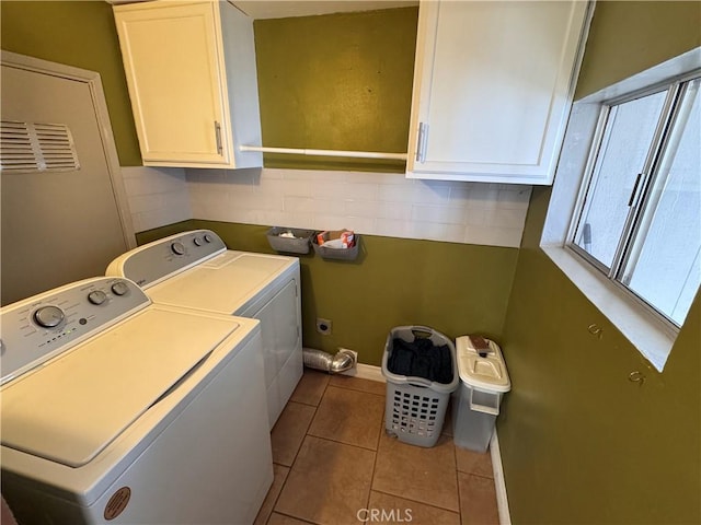 laundry room with cabinets, washing machine and dryer, and light tile patterned floors