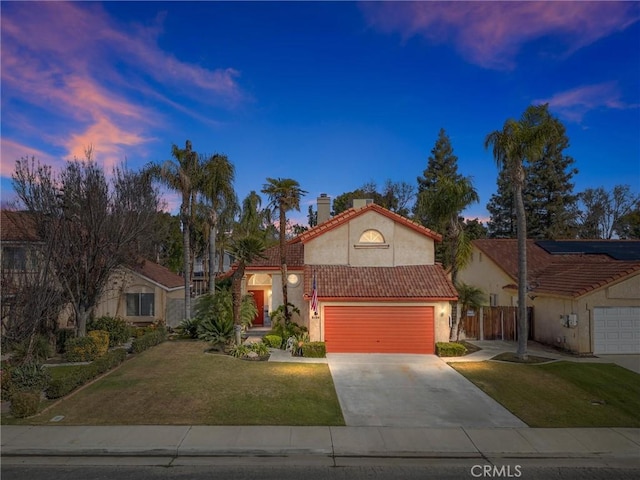 mediterranean / spanish-style house with a garage and a yard