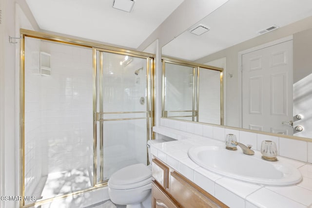 bathroom featuring vanity, an enclosed shower, and toilet