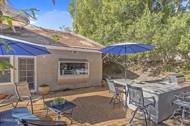 view of patio with exterior kitchen, area for grilling, and an outdoor bar