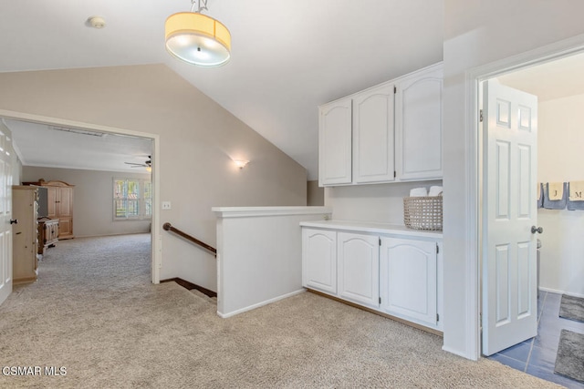 hall featuring light colored carpet and lofted ceiling