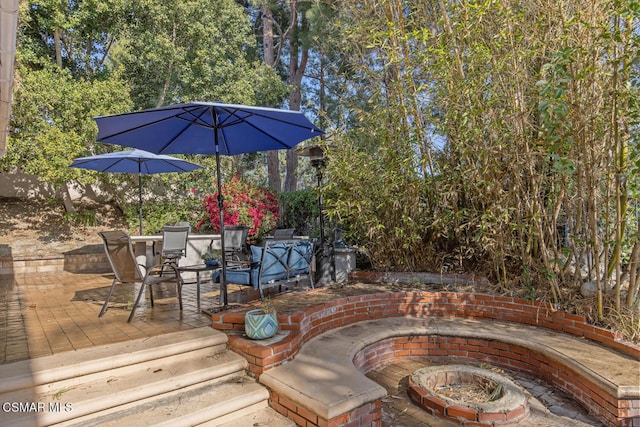 wooden terrace featuring a patio and an outdoor fire pit