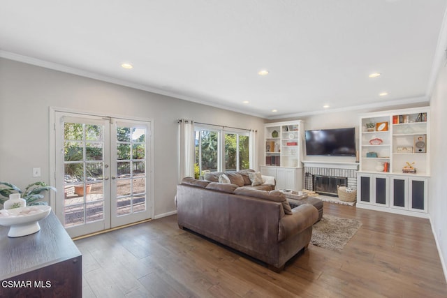 living room featuring french doors, a fireplace, hardwood / wood-style floors, and crown molding