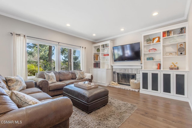 living room featuring crown molding, hardwood / wood-style floors, and a fireplace